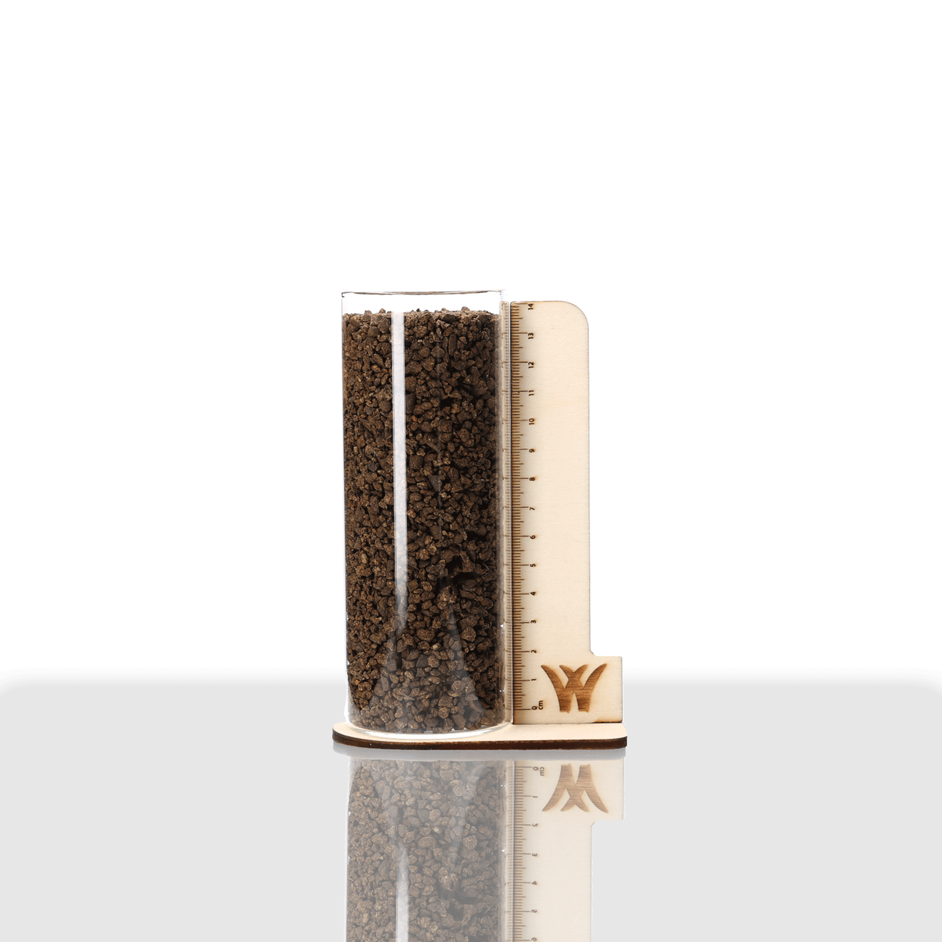 COMPO öko balance Gartendünger in Glaszylinder mit braunen Granulatkörnern und Holzhalterung mit Maßskala.